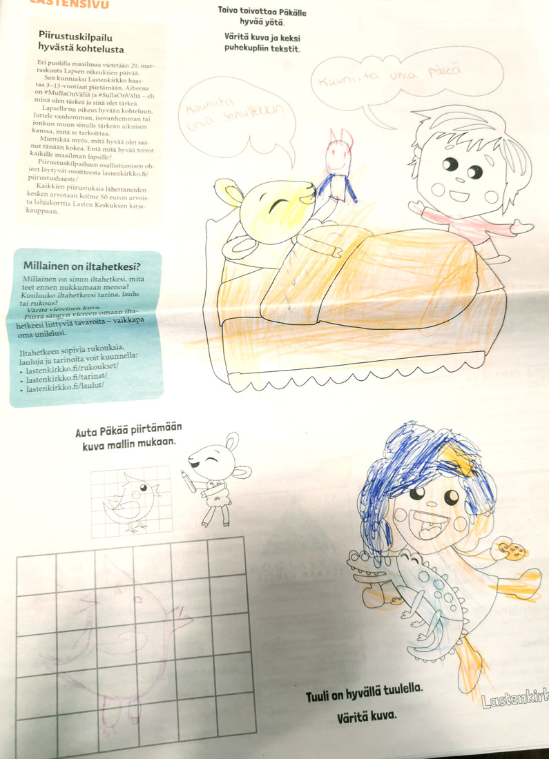 Lehden sivulla väritetty kuva, jossa on Päkä-lammas ja sen vieressä lapsi.